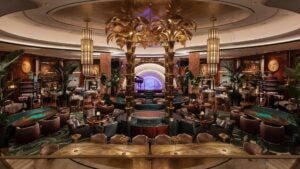 restaurant interior with stage, plush seating, gold chandeliers, alcohol on shelves